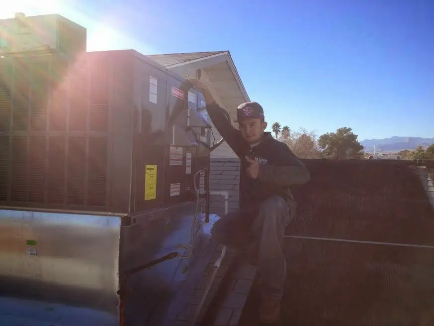HVAC technician performing Air Duct Repair on a rooftop unit in Fort Dodge